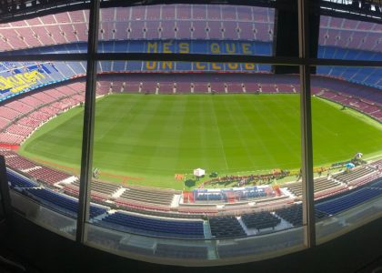Wide view of Camp Nou stadium showcasing its vast seating and green pitch.
